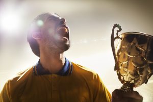 Meninger athlete holding trophy cup in stadium